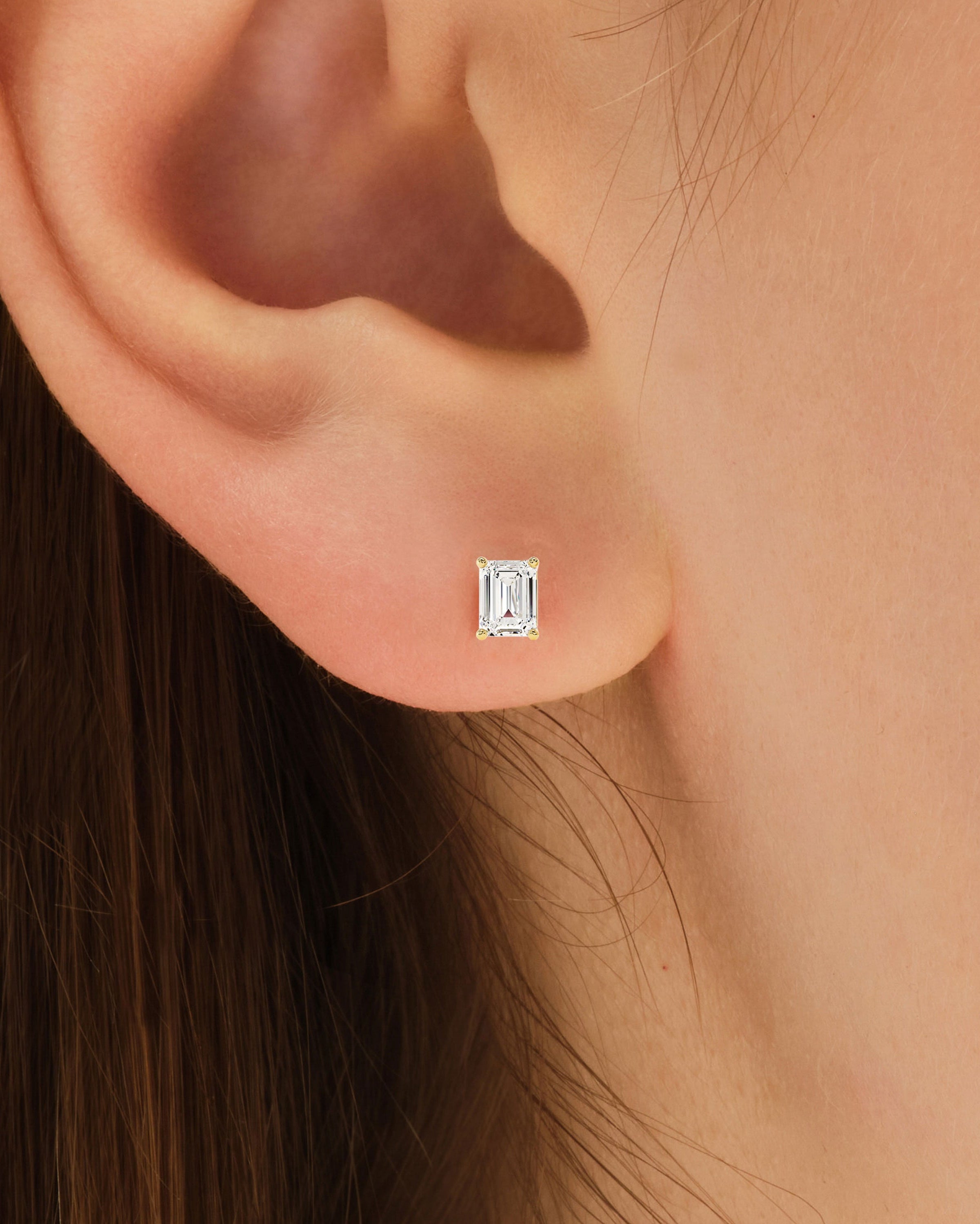 Emerald cut diamond stud earring on ear