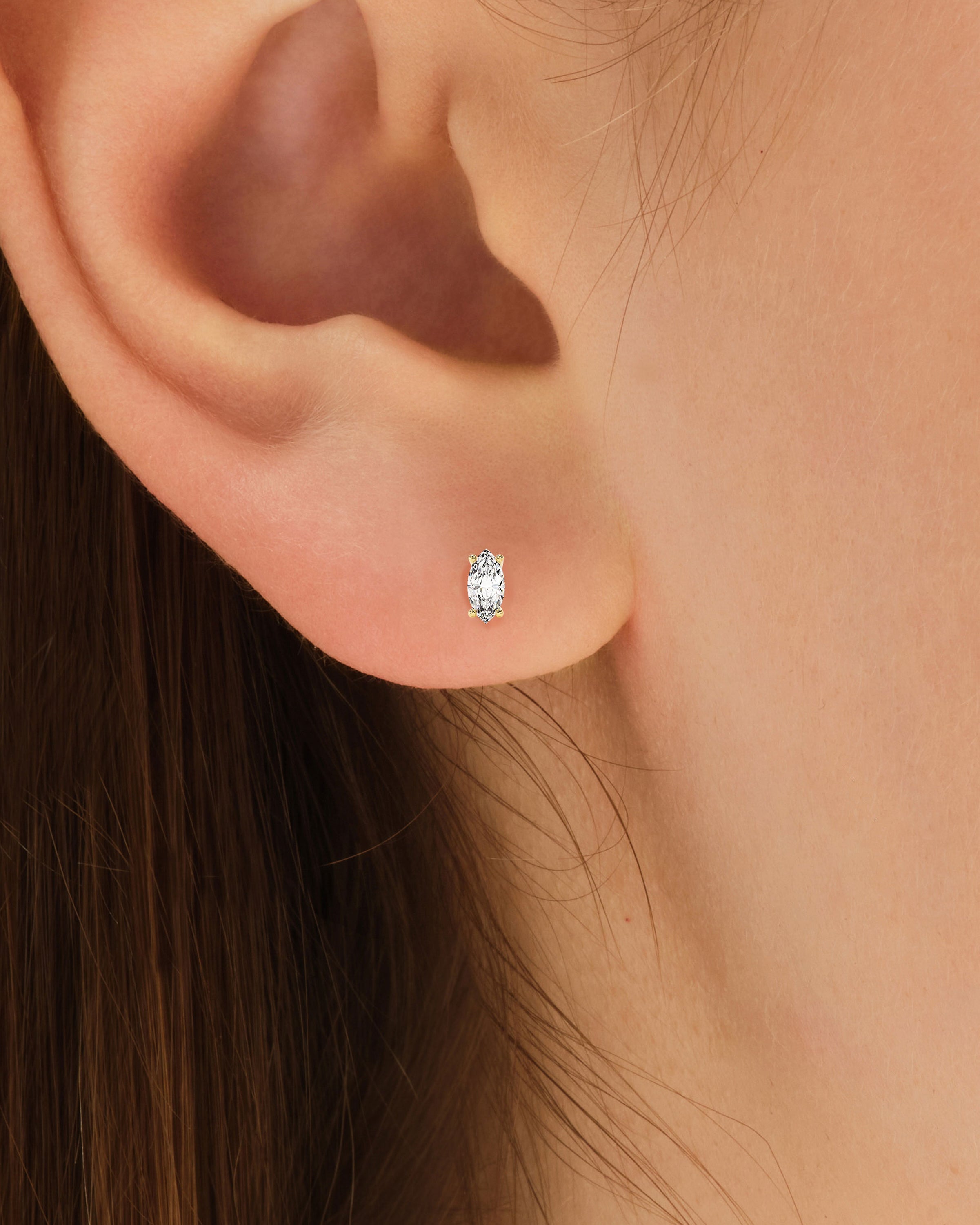 Diamond stud earring on a woman's ear, jewelry product