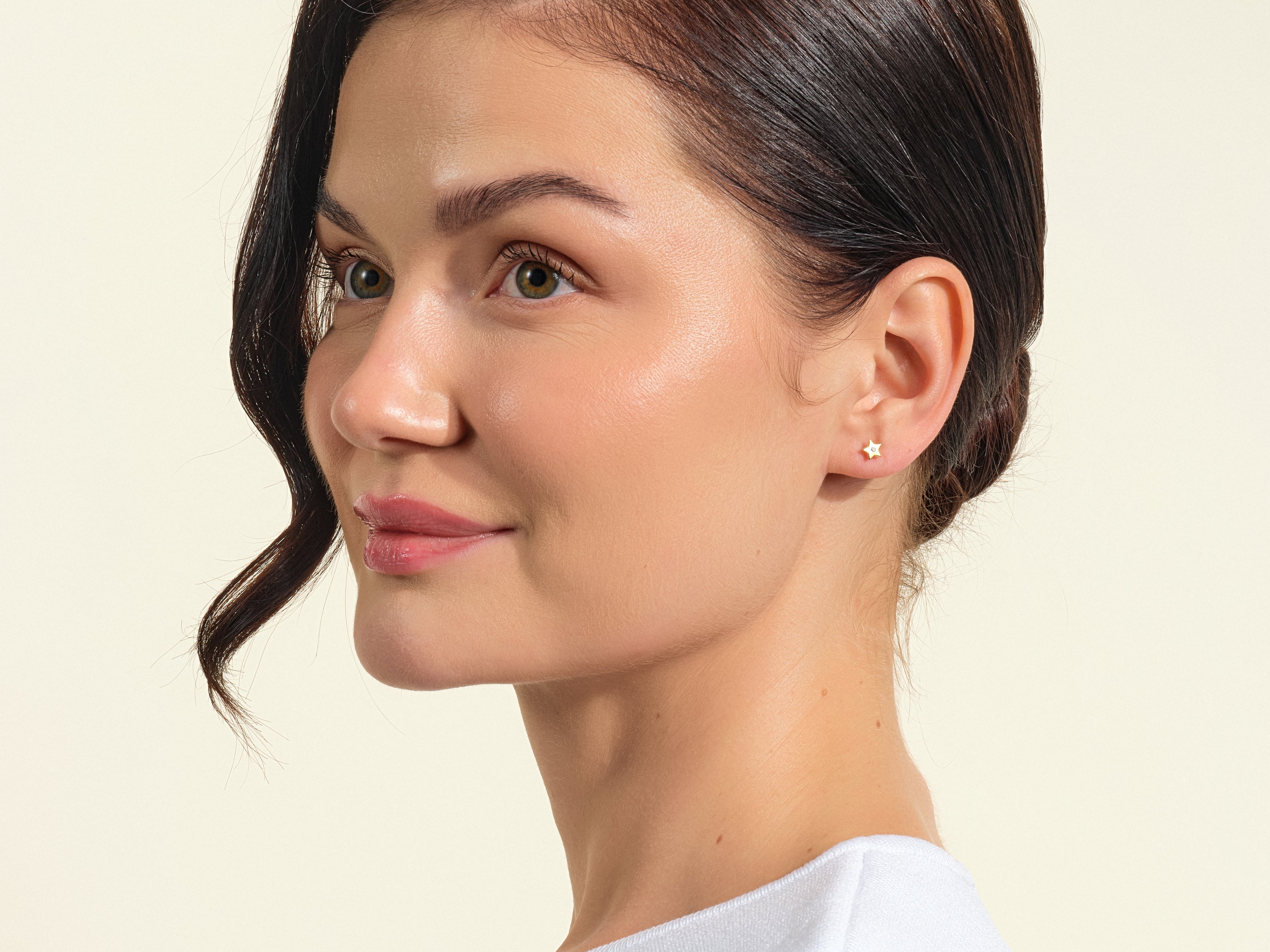 Gold star stud earring with diamond accent on model
