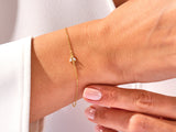 Gold bracelet with diamond bee charm on wrist