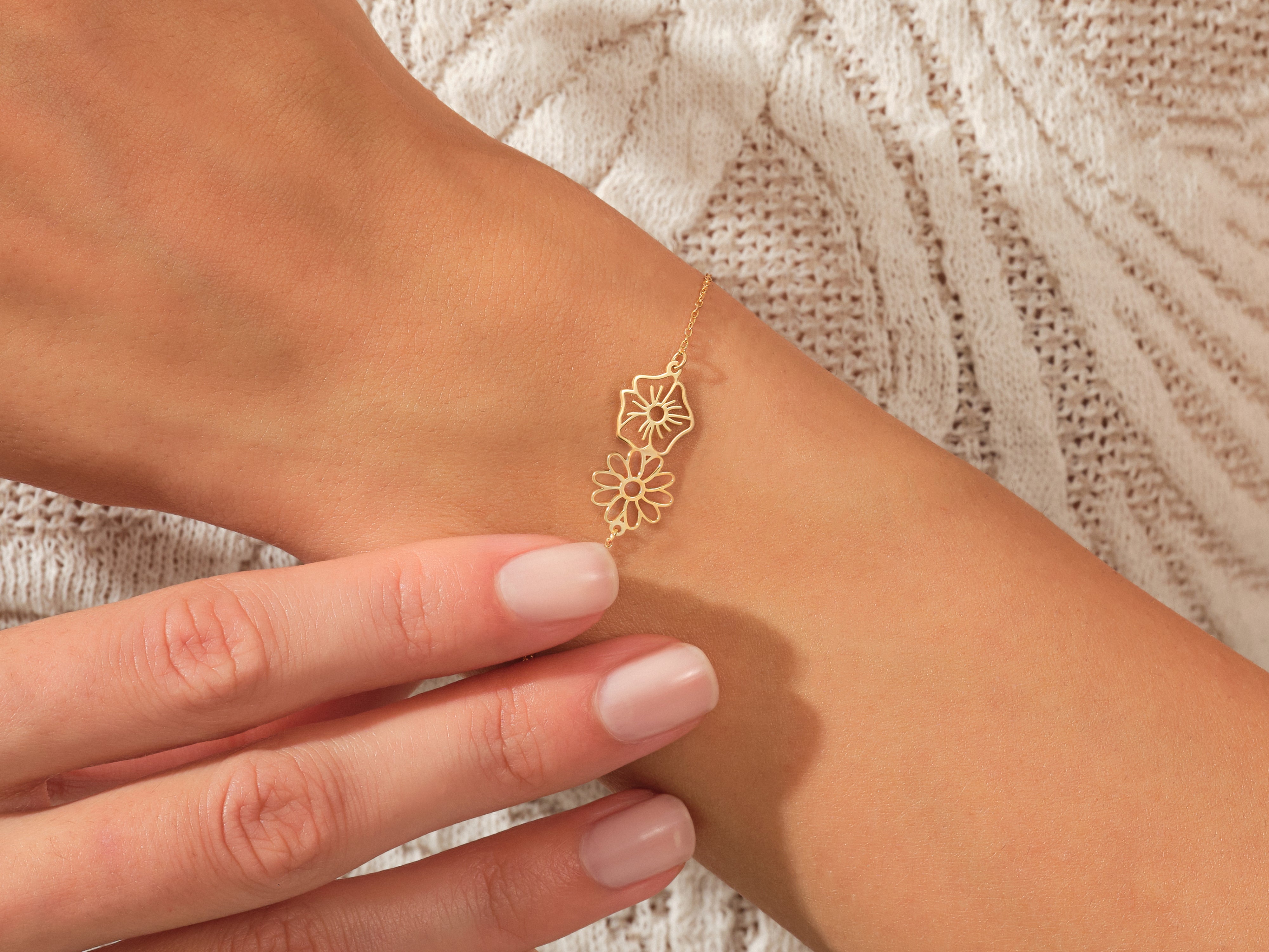 Gold floral bracelet on a woman's wrist