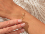 Gold floral bracelet on a woman's wrist