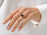 Gold signet ring with black onyx gemstone on a woman's hand
