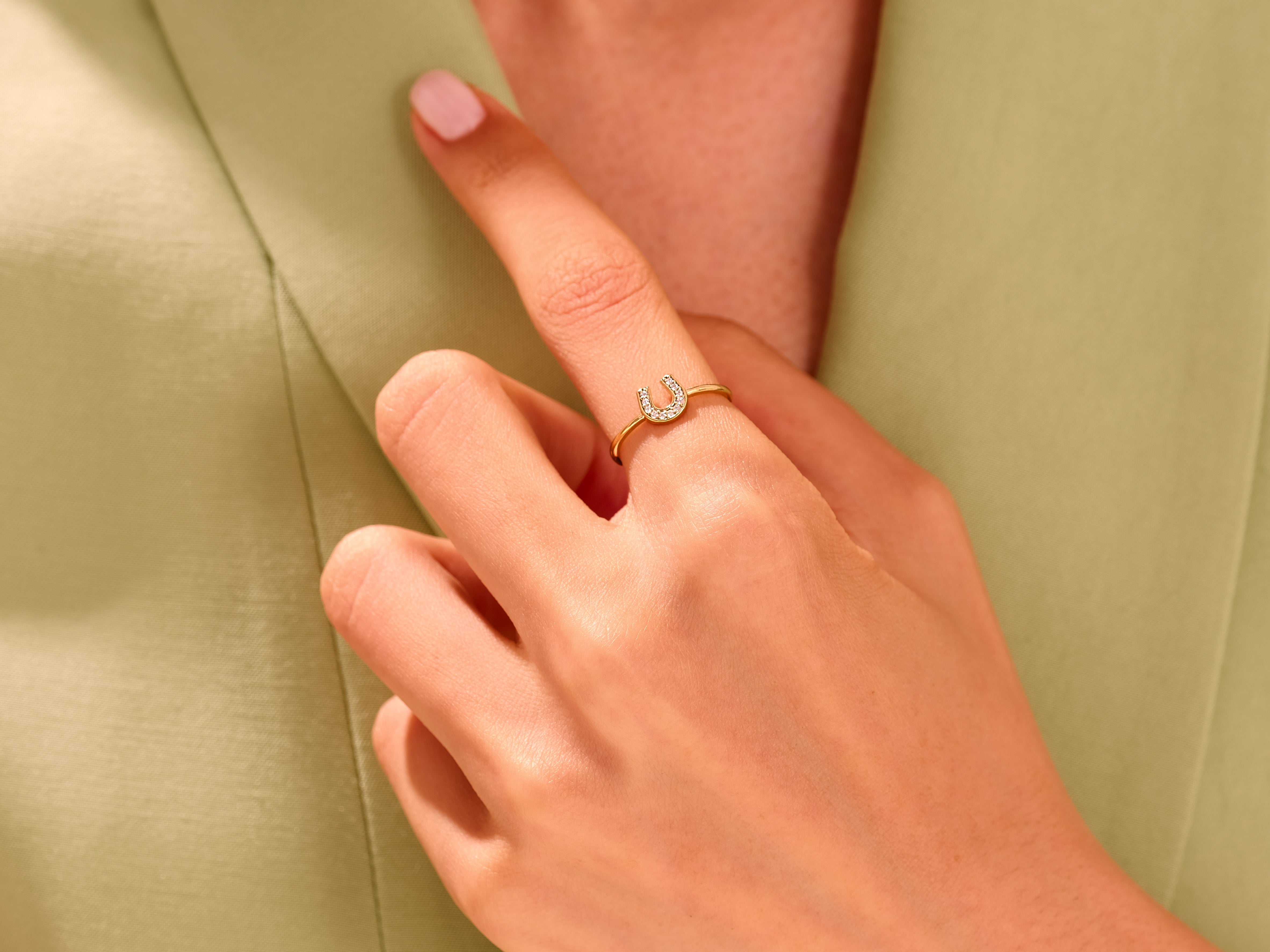 Diamond horseshoe ring on a finger, fine jewelry