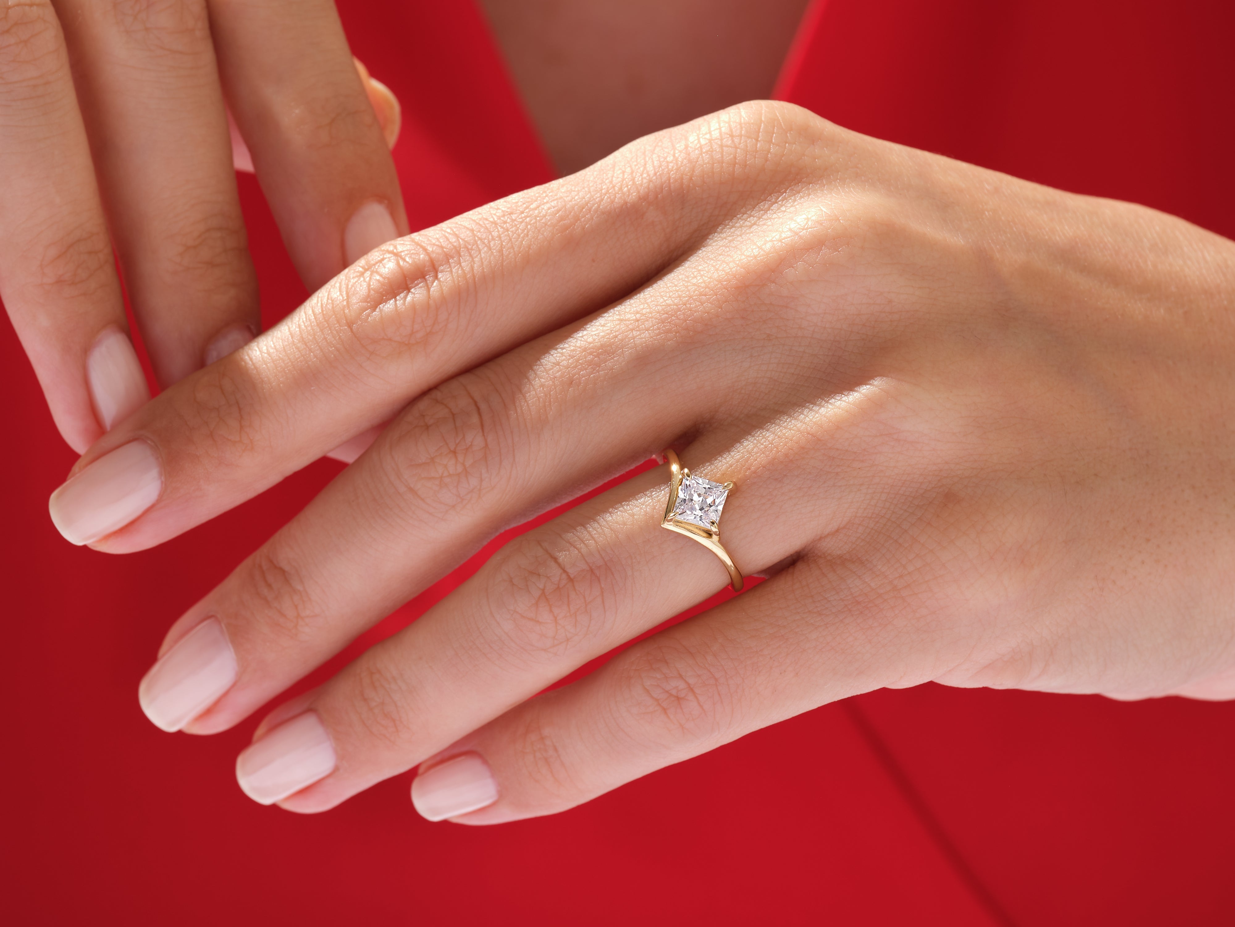 Gold ring with princess cut diamond on a woman's hand
