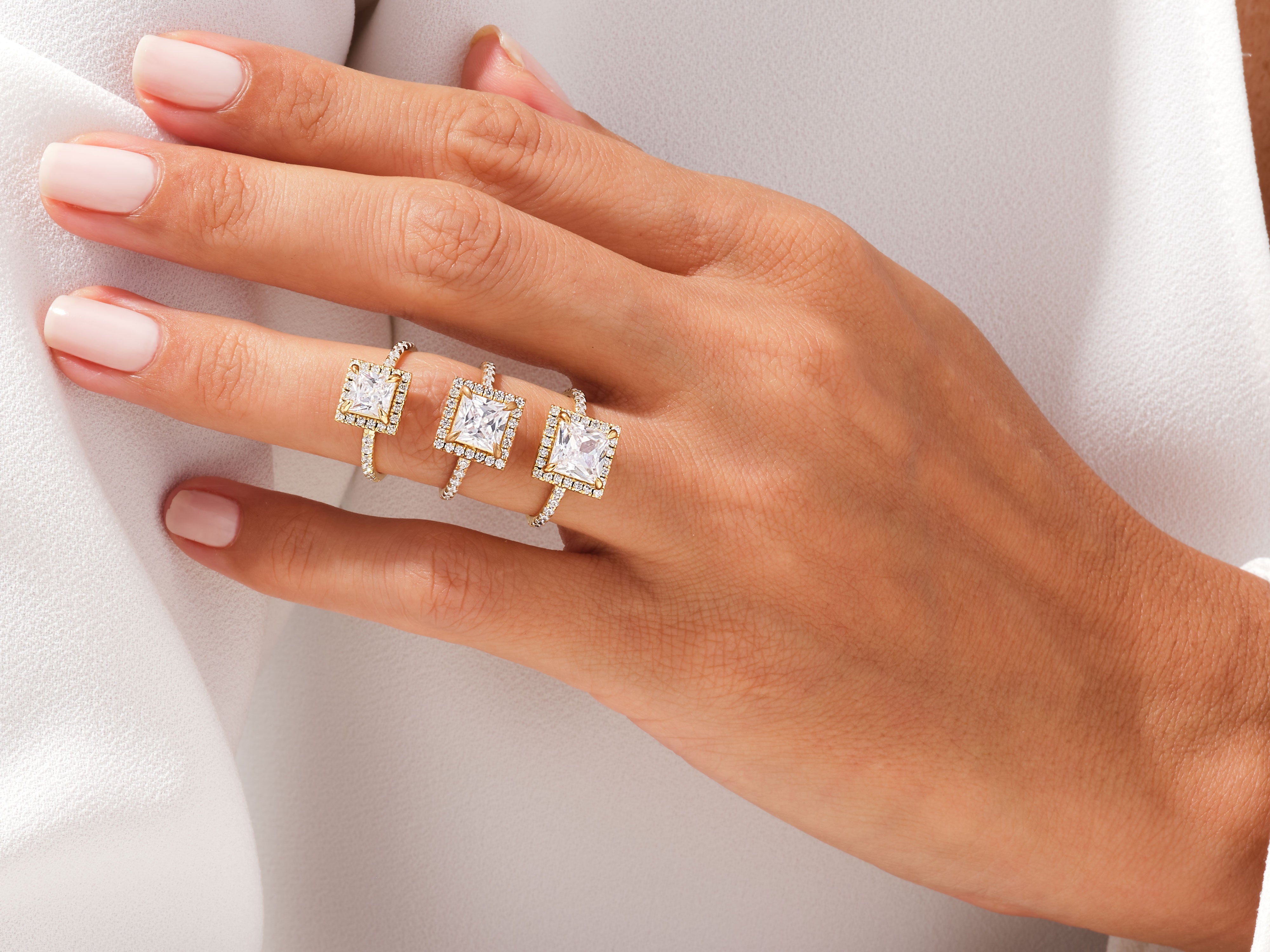 Diamond engagement rings on a hand, jewelry collection