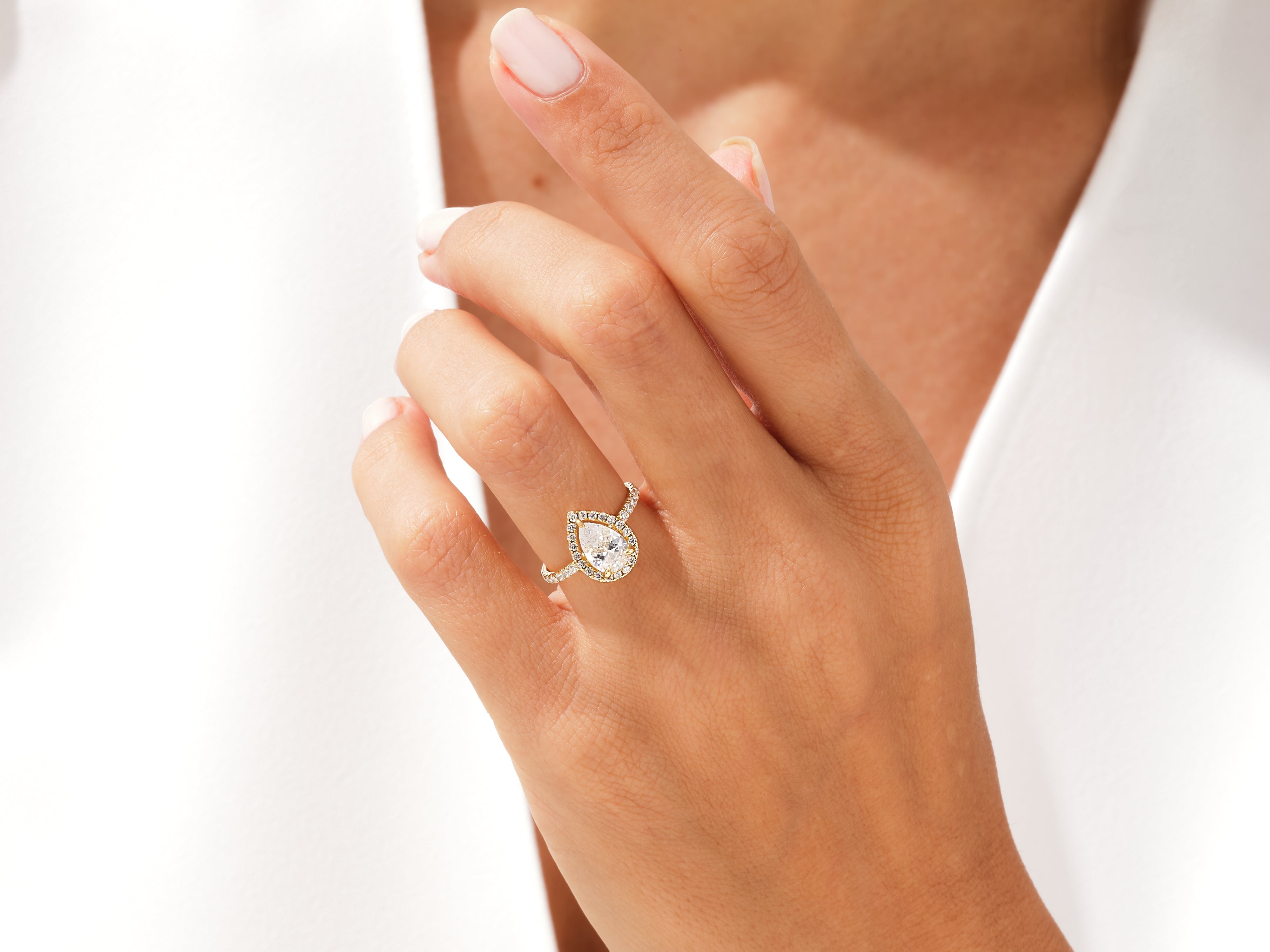 Pear-shaped diamond engagement ring with halo, gold band