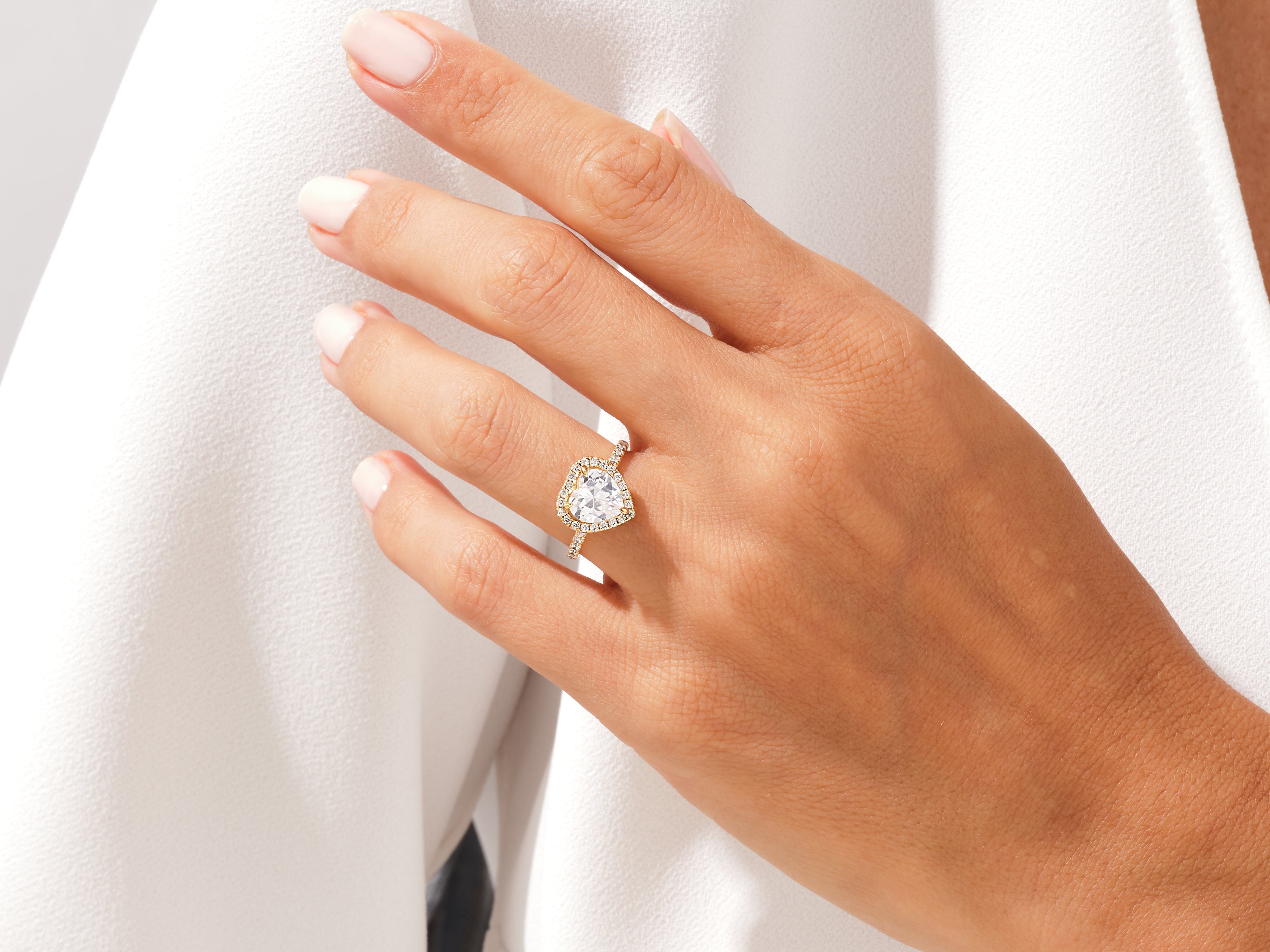 Heart-shaped diamond engagement ring on a woman's hand