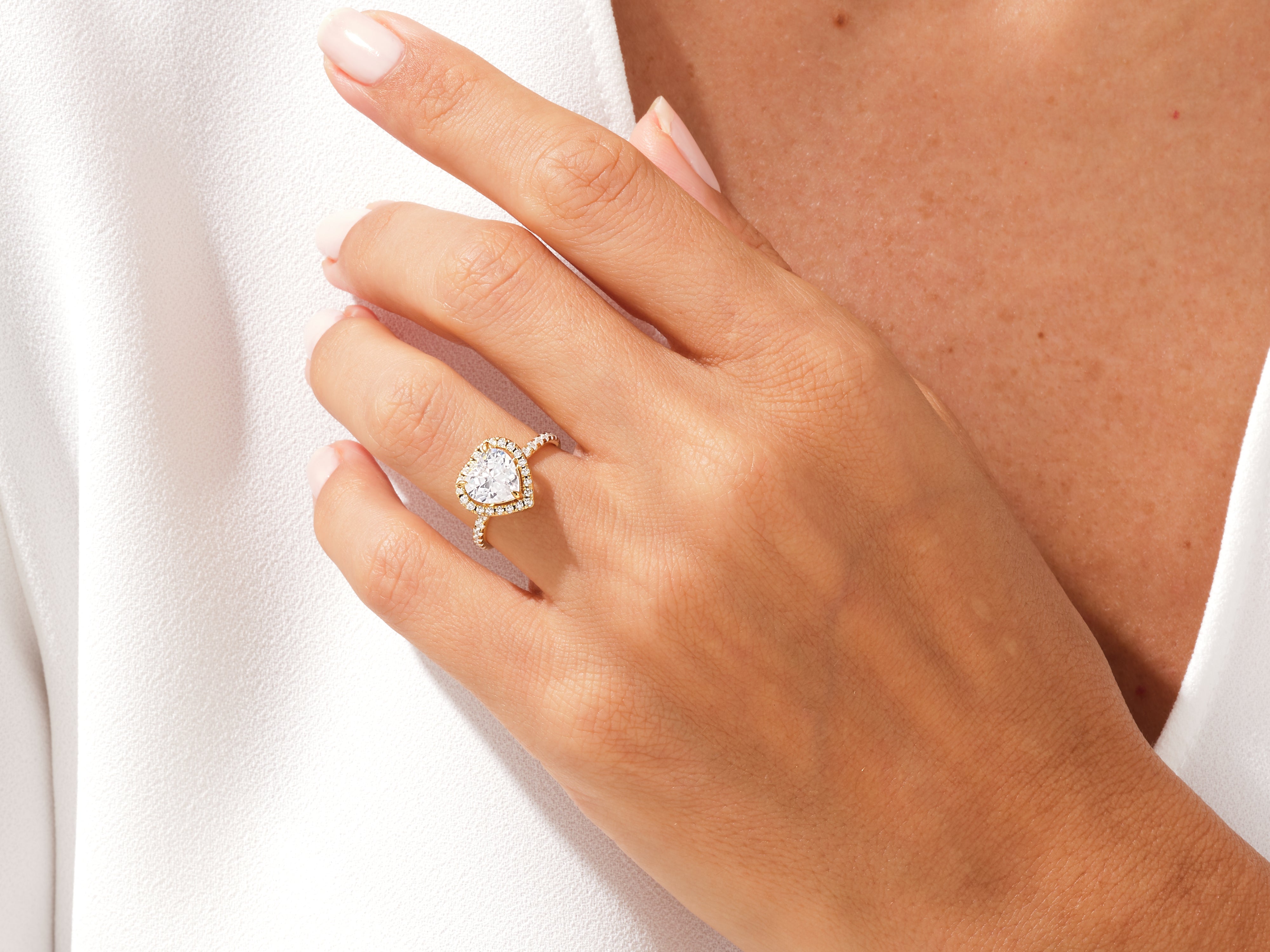 Heart-shaped diamond engagement ring on a woman's hand