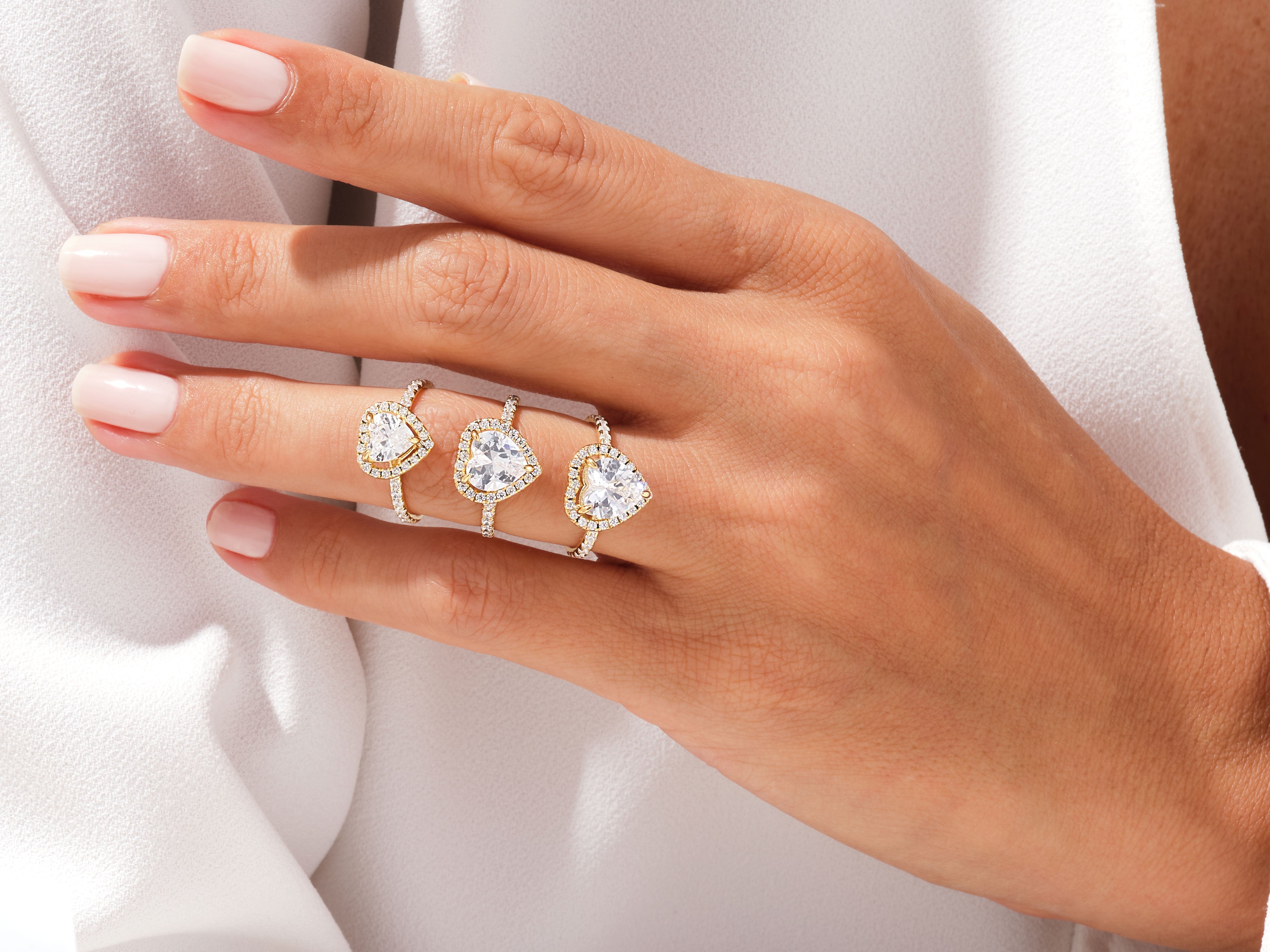 Diamond heart rings on a hand, jewelry collection
