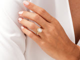 Gold halo engagement ring with oval diamond on hand