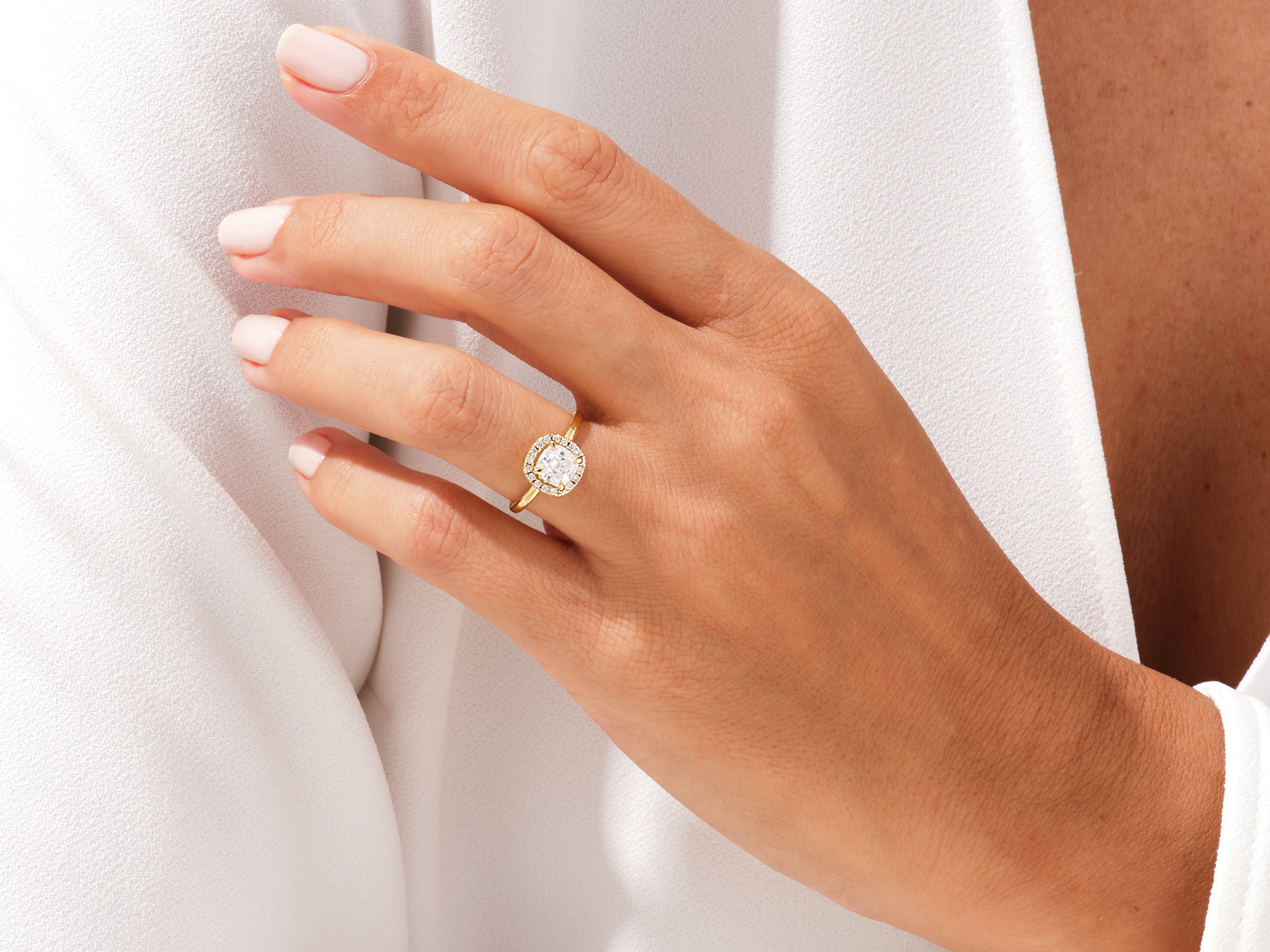 Gold halo engagement ring on a woman's hand