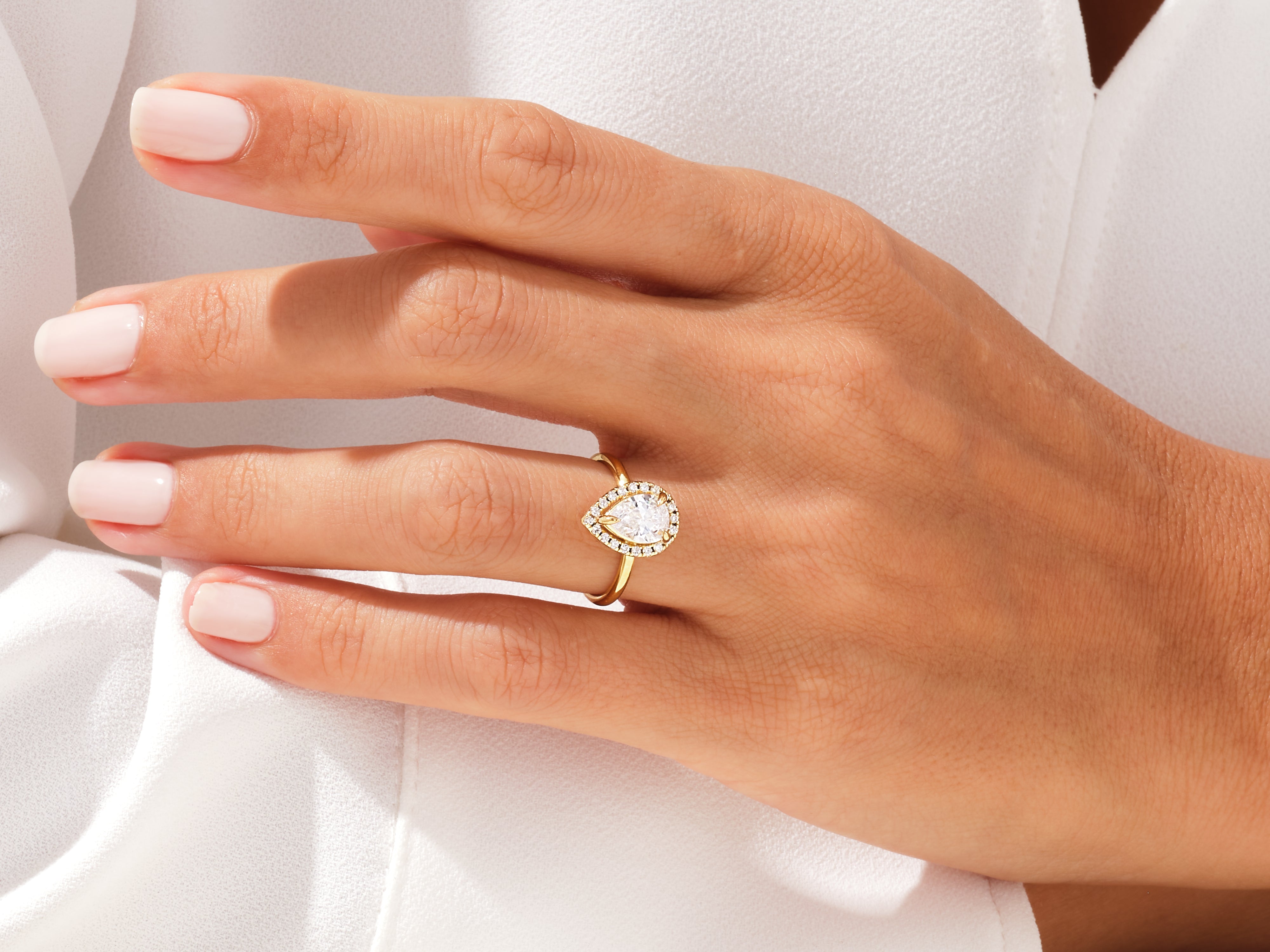 Pear-shaped diamond engagement ring on a woman's hand