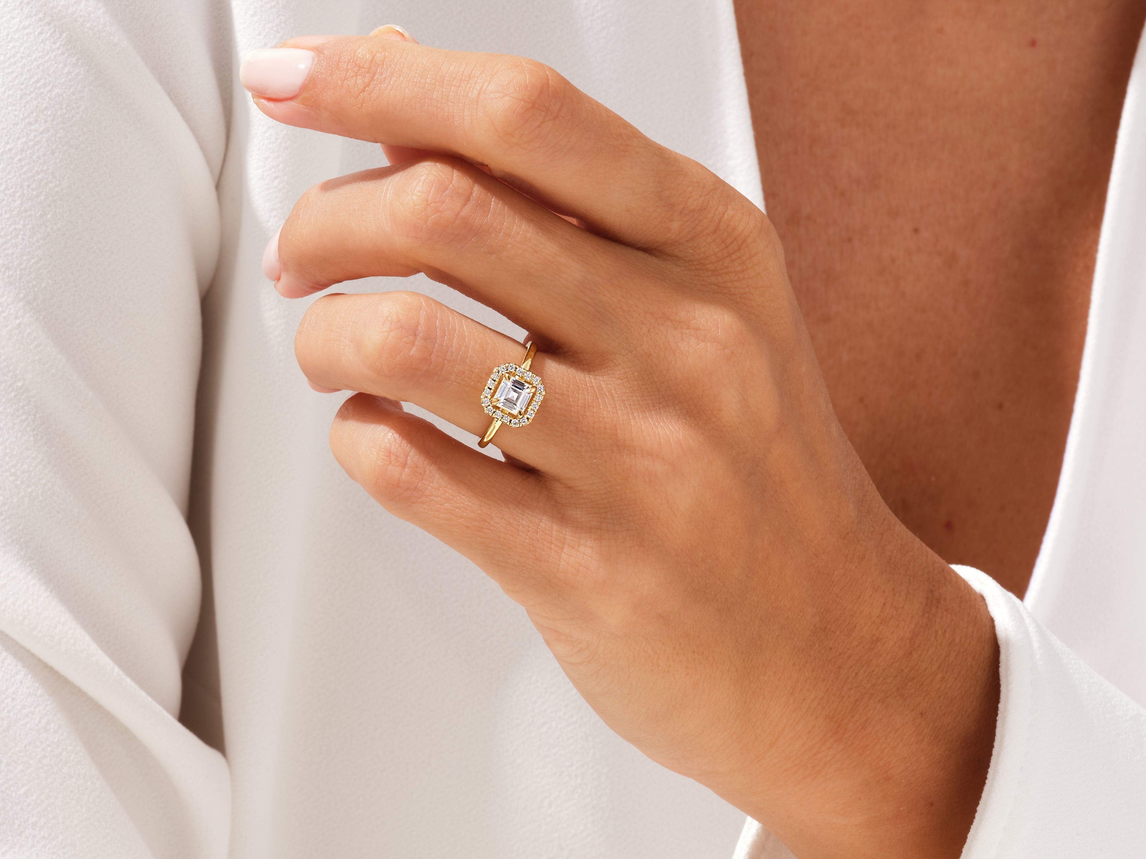 Gold ring with emerald cut diamond and diamond halo