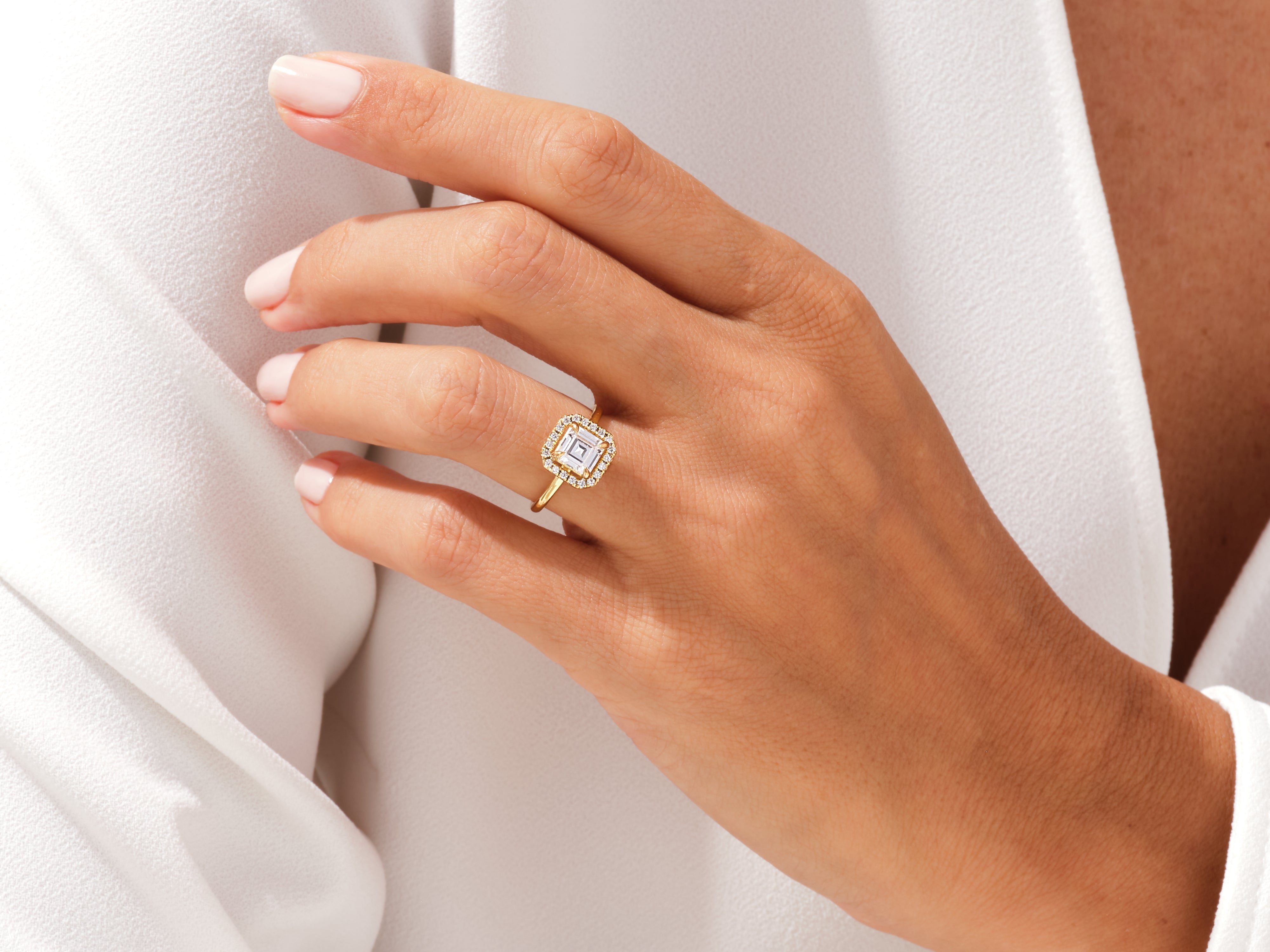 Gold diamond halo ring on a woman's hand