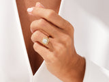 Gold halo ring with emerald-cut diamond on hand