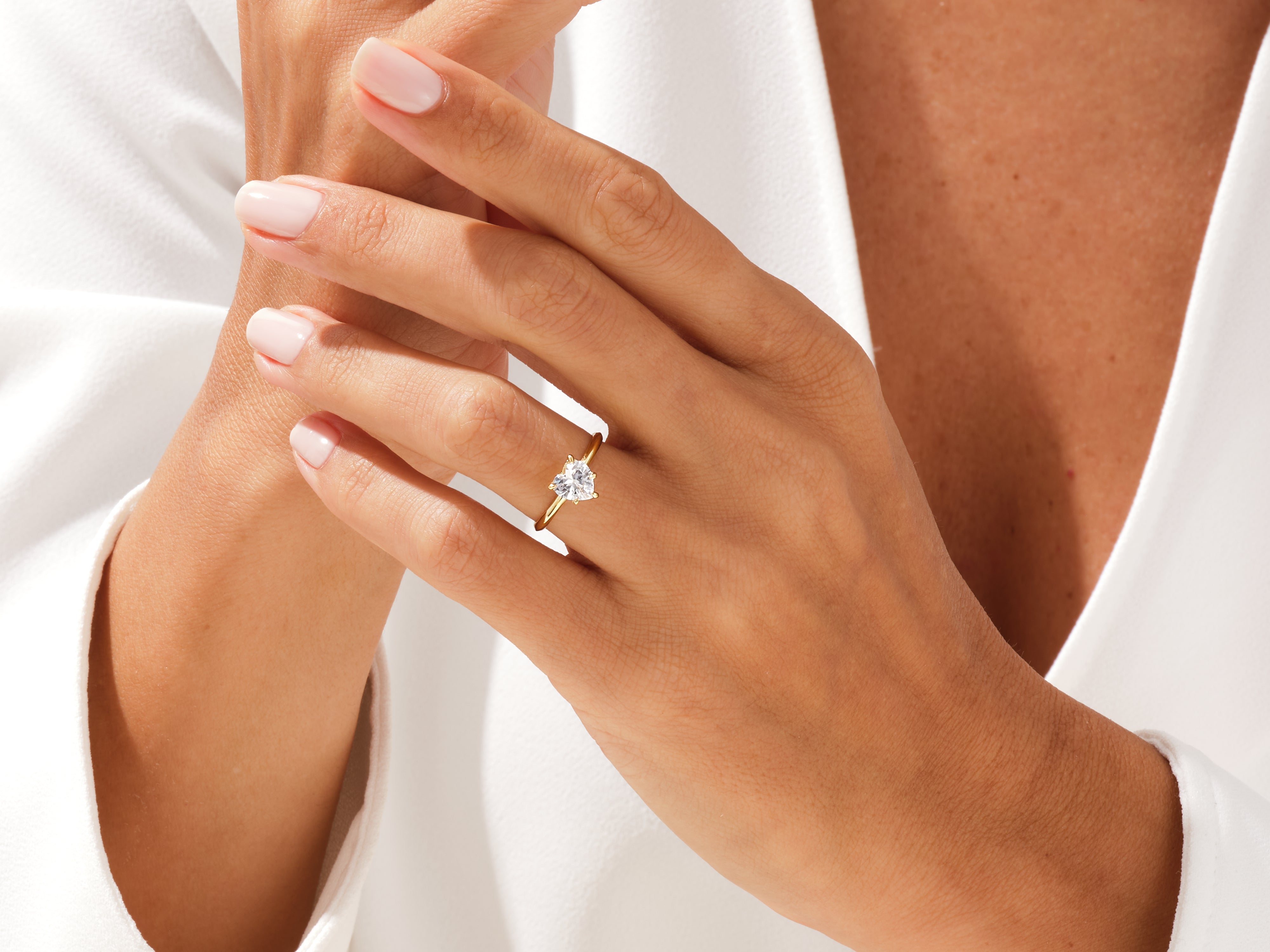 Heart-shaped diamond engagement ring on a woman's hand