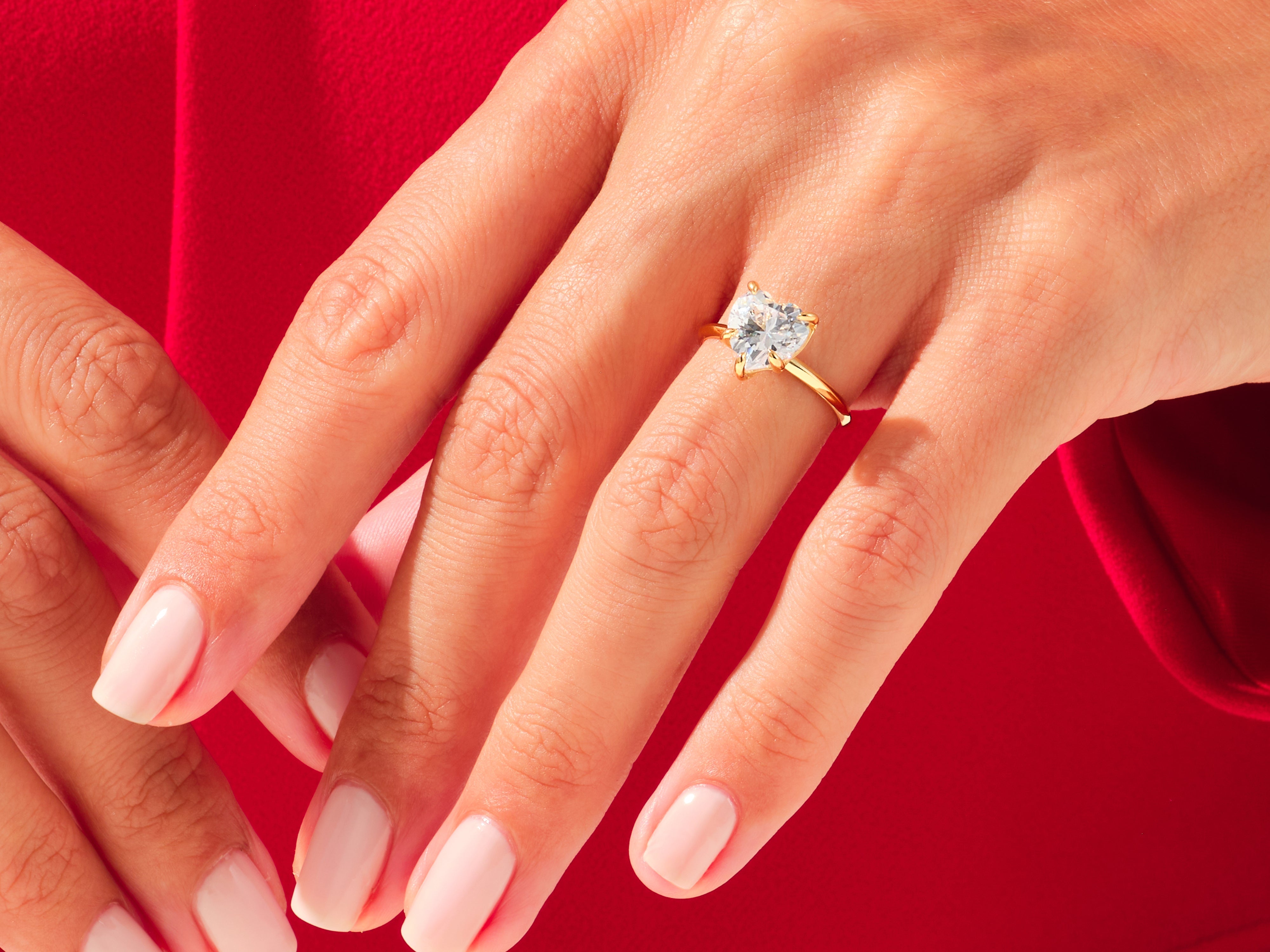 Heart-shaped diamond engagement ring on a woman's hand