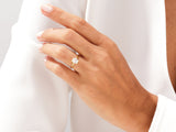 Gold ring with emerald-cut diamond on a woman's finger