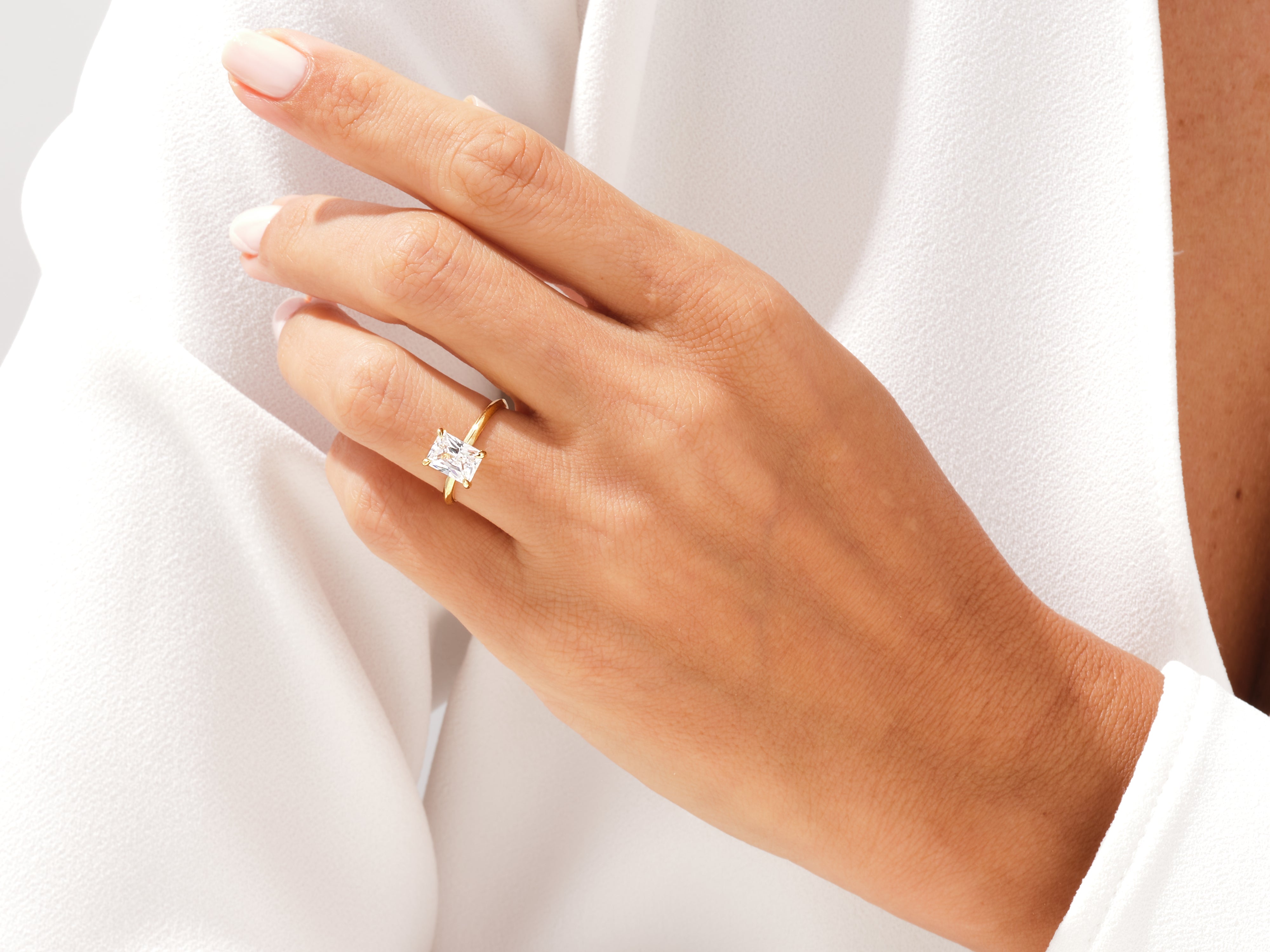 Gold ring with radiant cut diamond on a woman's finger