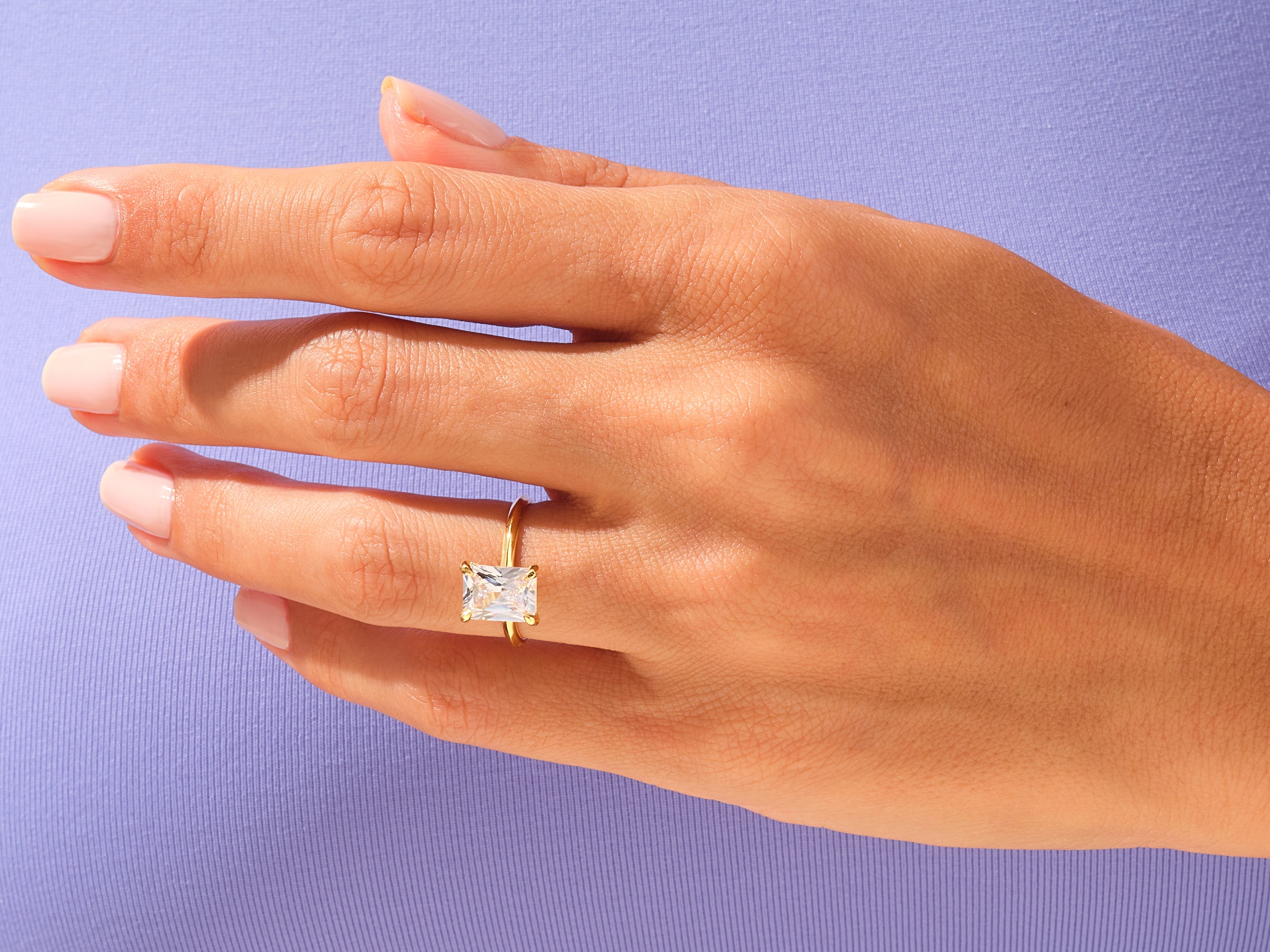 Gold ring with radiant cut diamond on hand