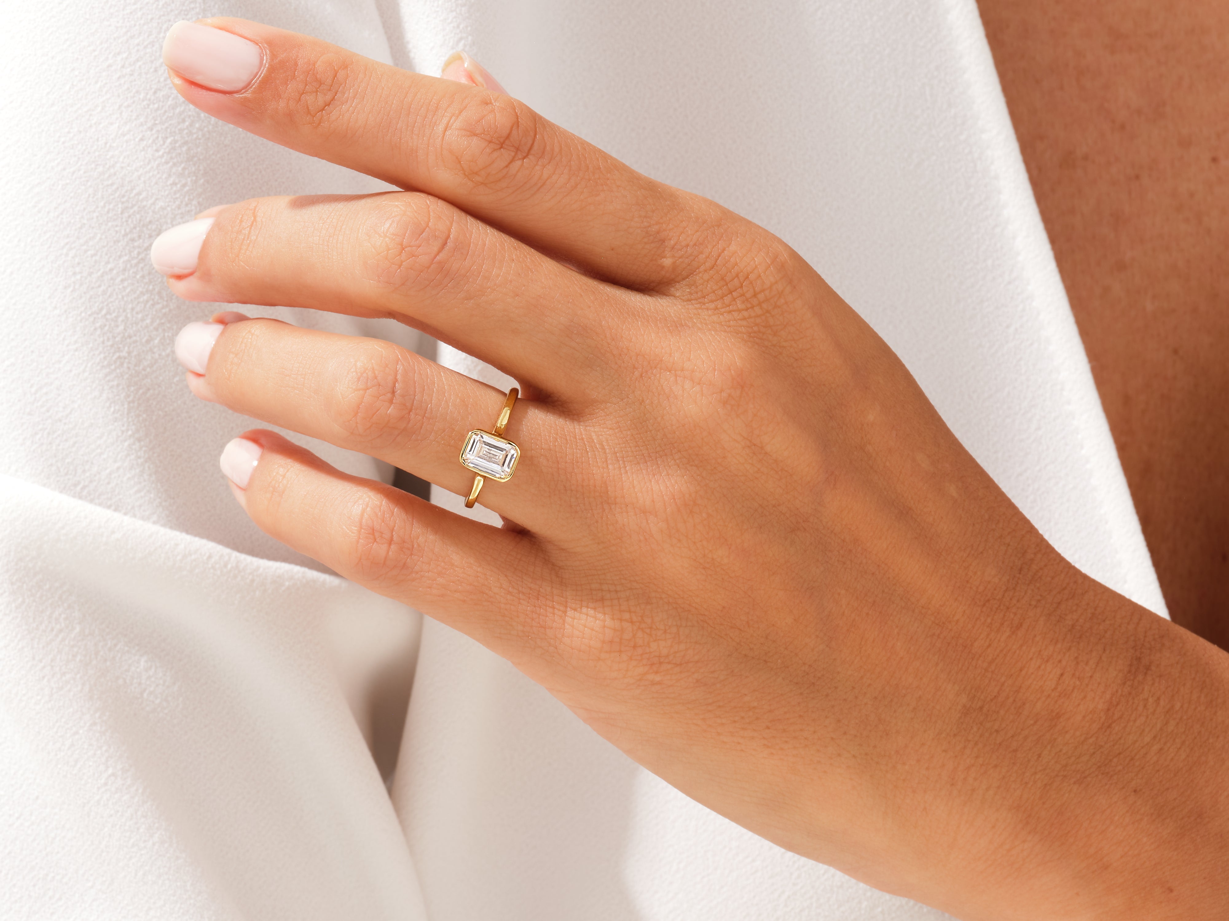 Gold ring with emerald-cut diamond on hand