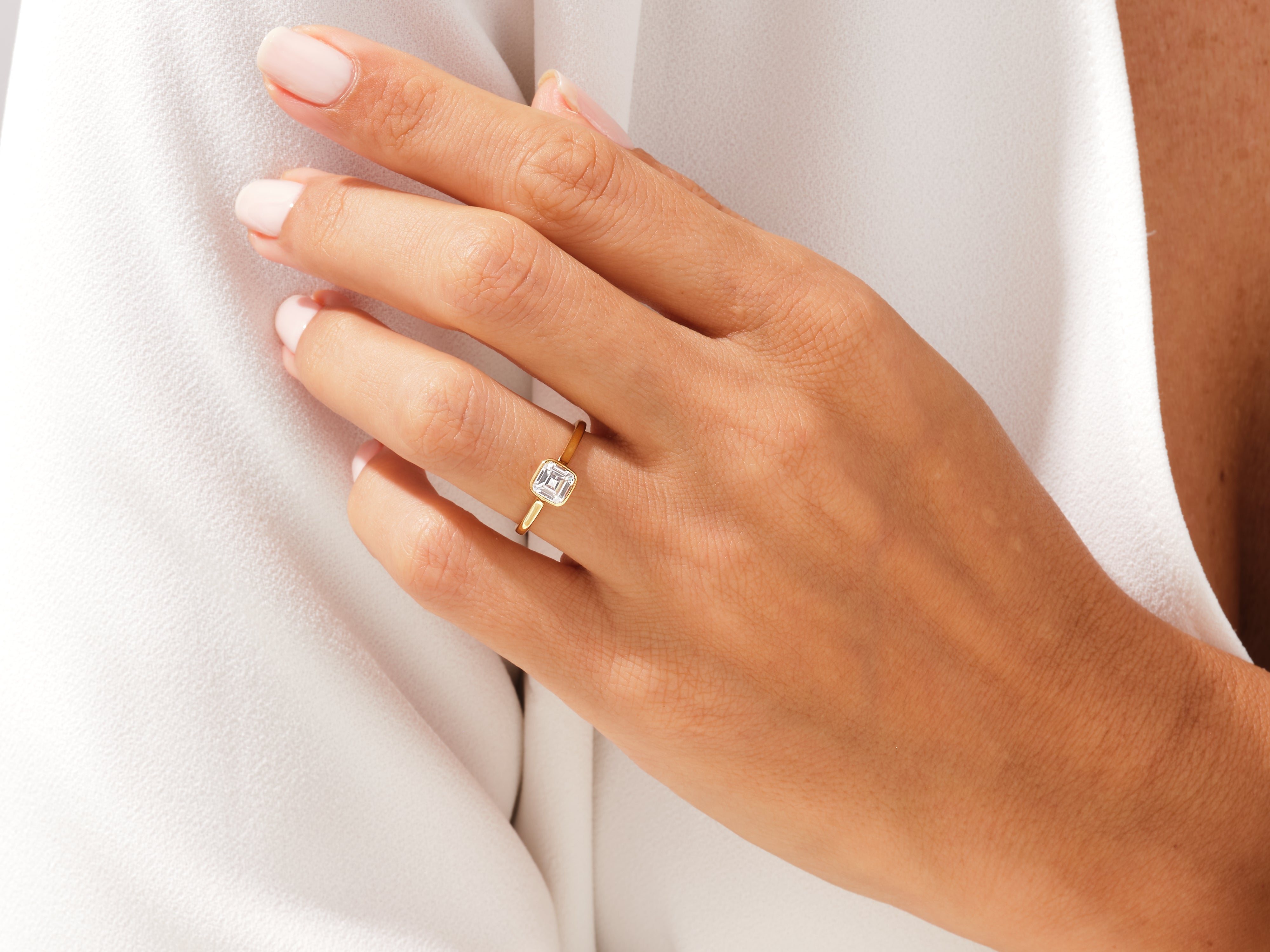 Gold ring with emerald cut diamond on hand