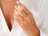 Gold ring with emerald cut diamond on a woman's hand