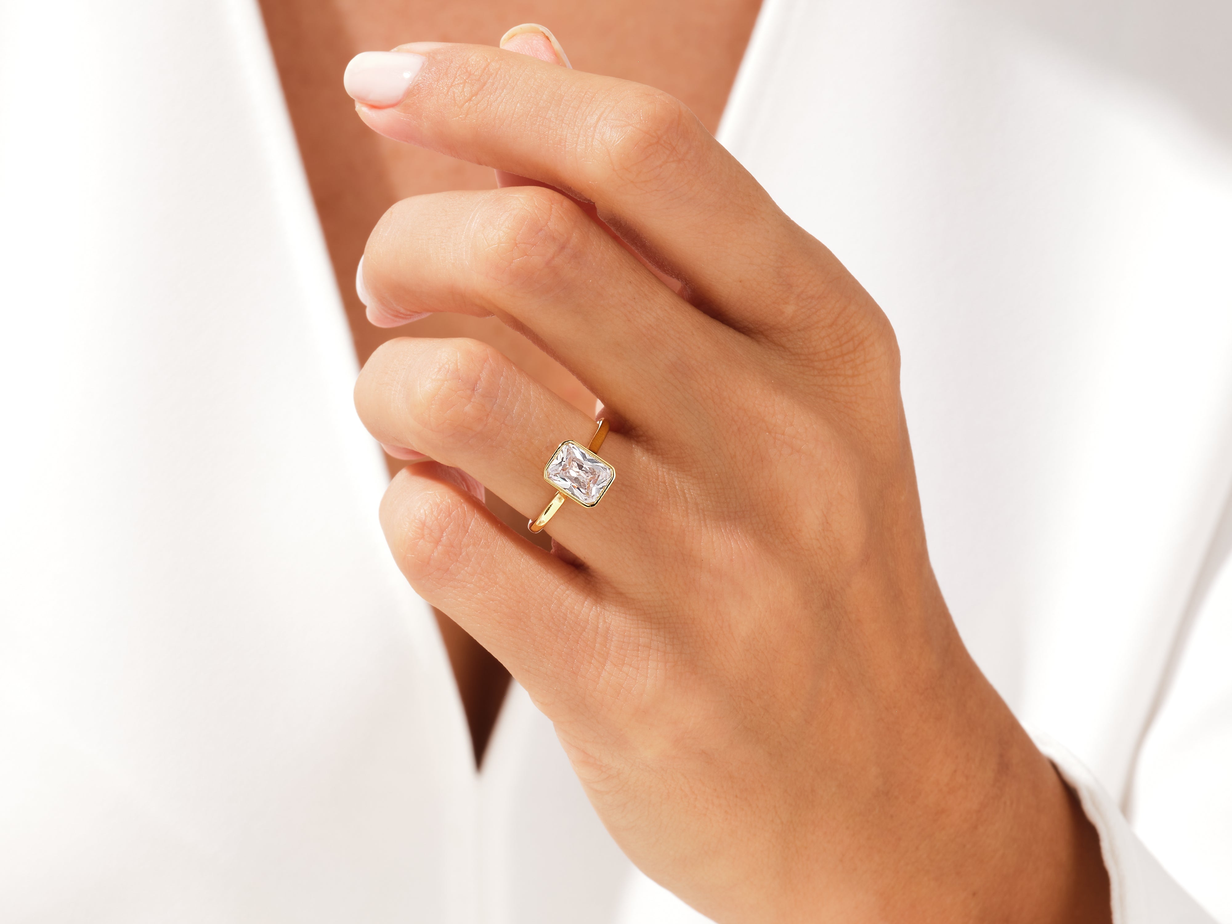 Gold ring with emerald cut diamond on hand