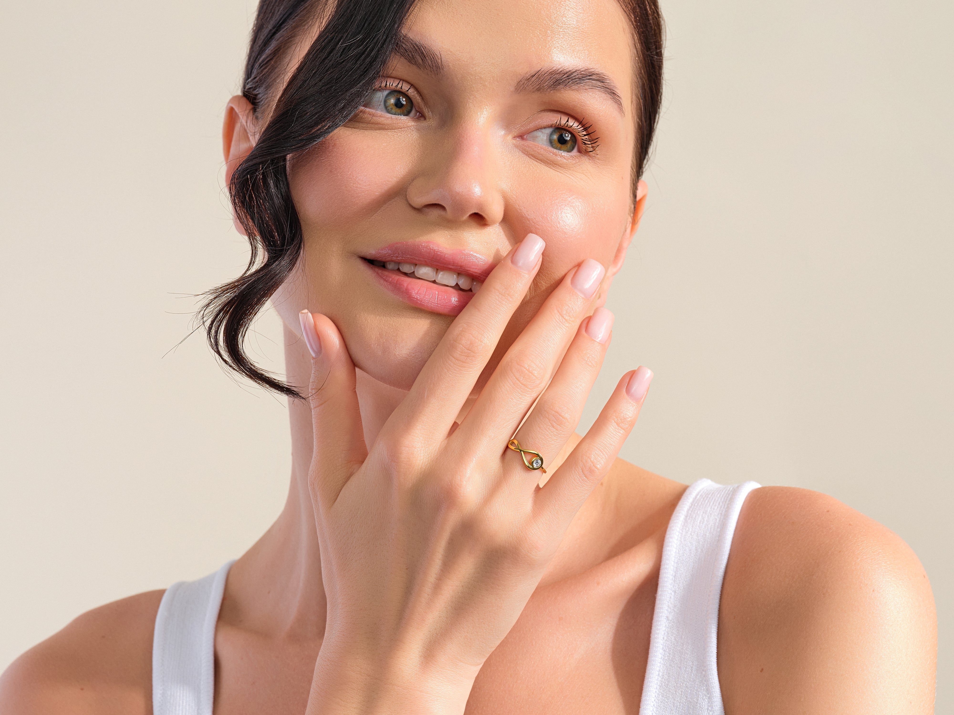 Woman wearing a gold infinity ring with diamond accent