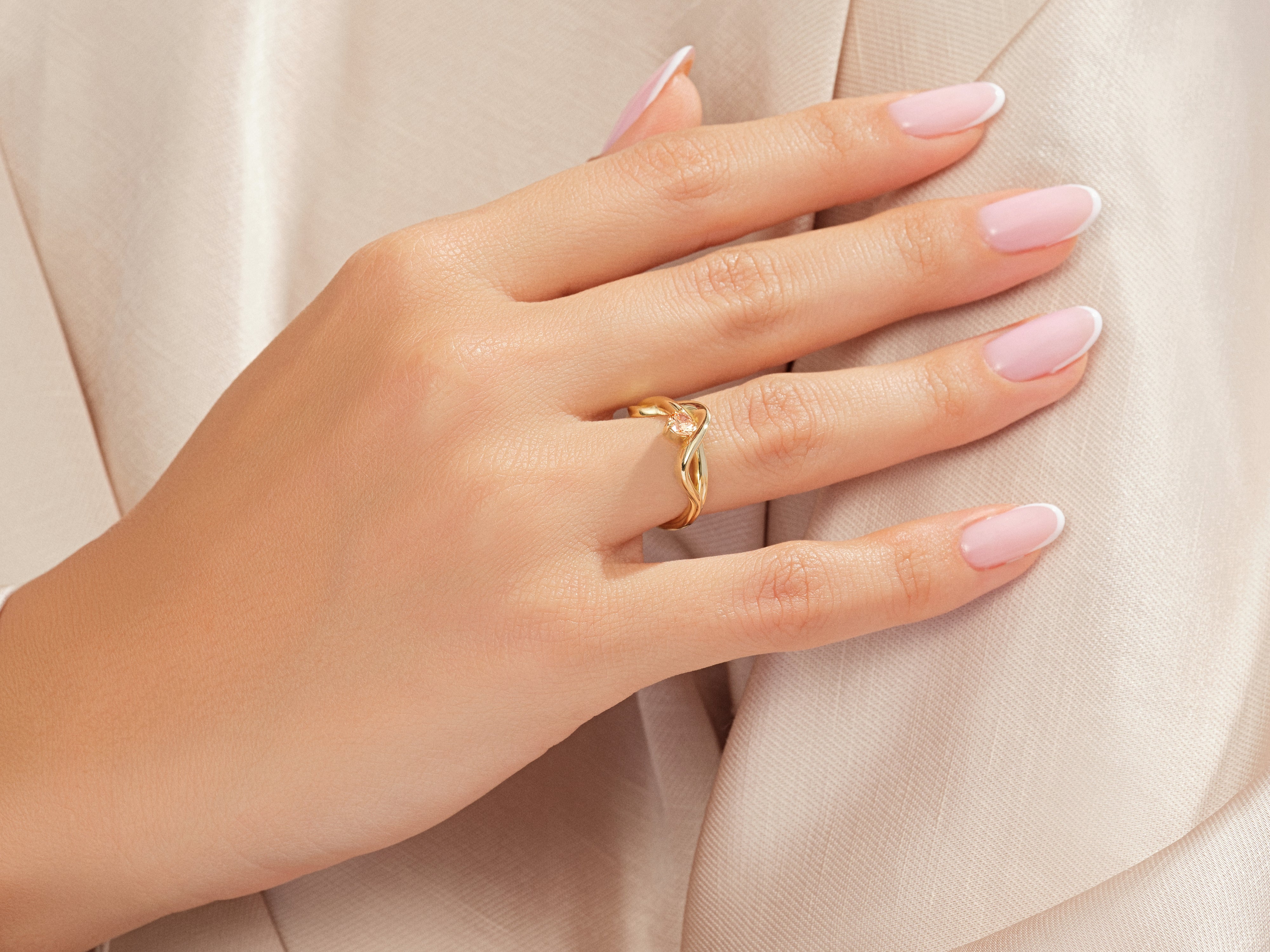 Gold ring with pink stone on a woman's hand