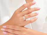 Diamond engagement ring with two pear-shaped stones on a woman's hand