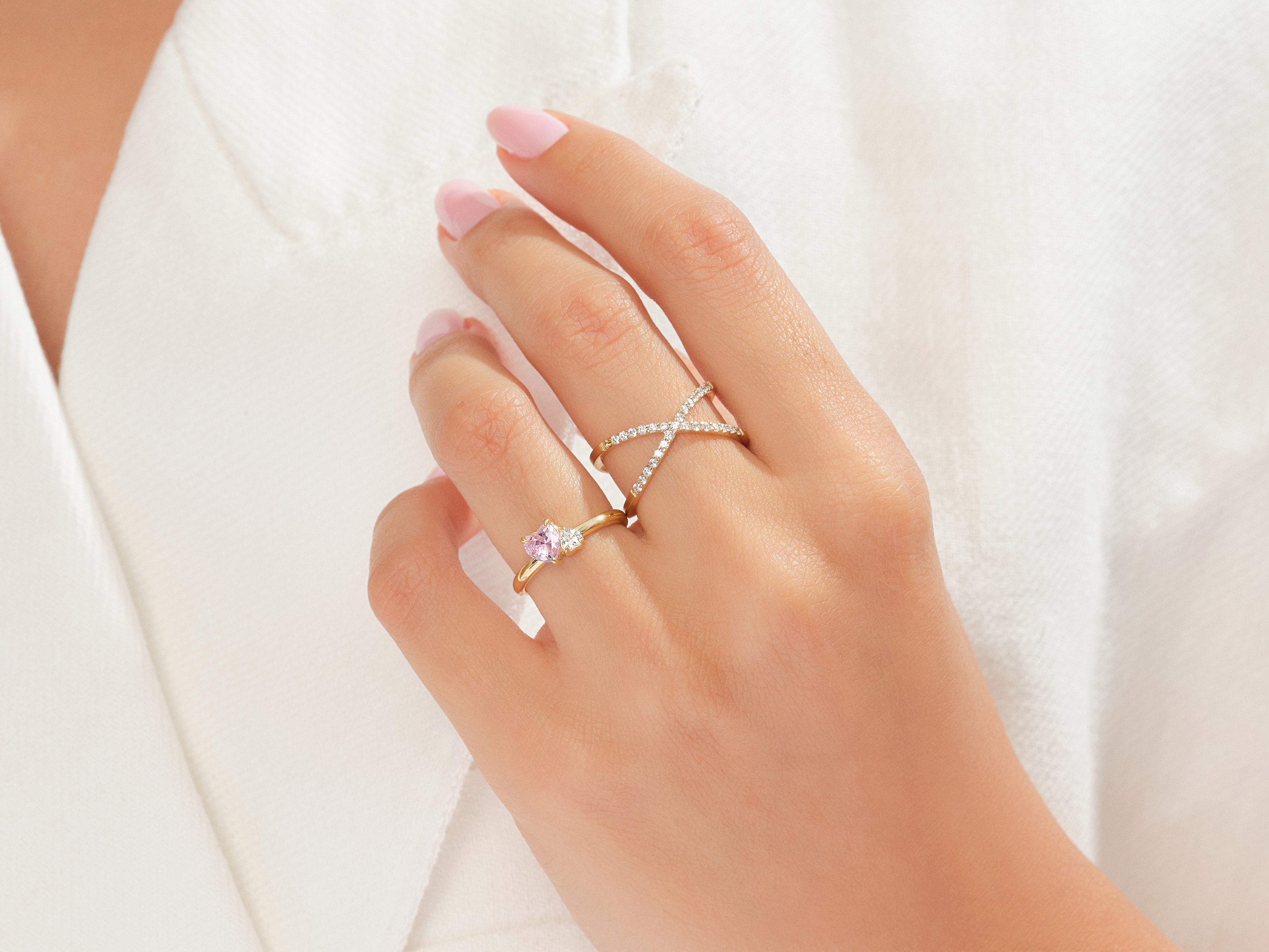 Gold rings with pink gemstone and diamonds on hand