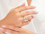 Gold ring with pink heart gemstone on a woman's finger
