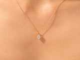 Gold heart necklace with diamond pendant on skin
