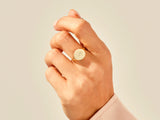 Gold signet ring with initial 'P' on a hand