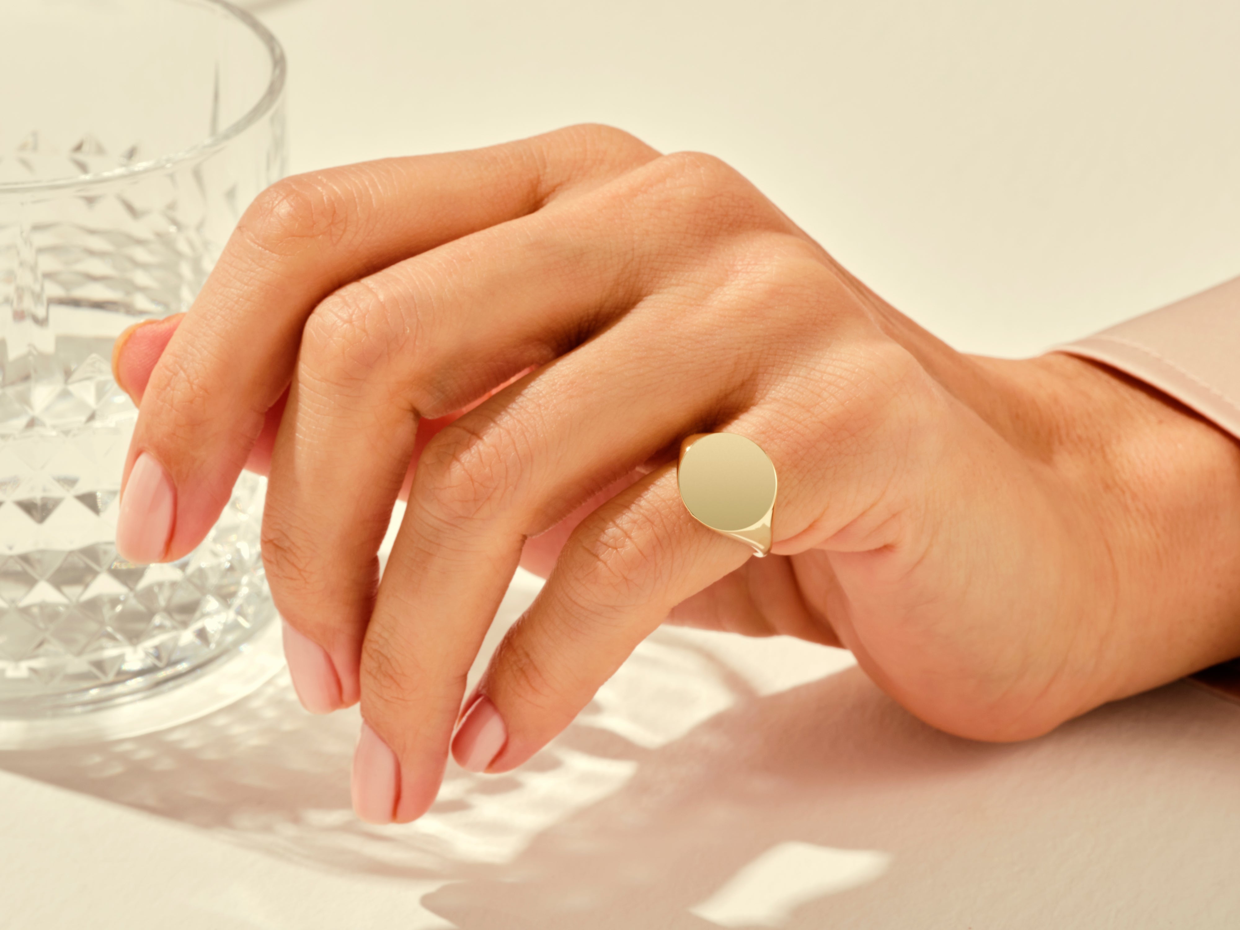 Gold signet ring on a woman's hand, elegant jewelry