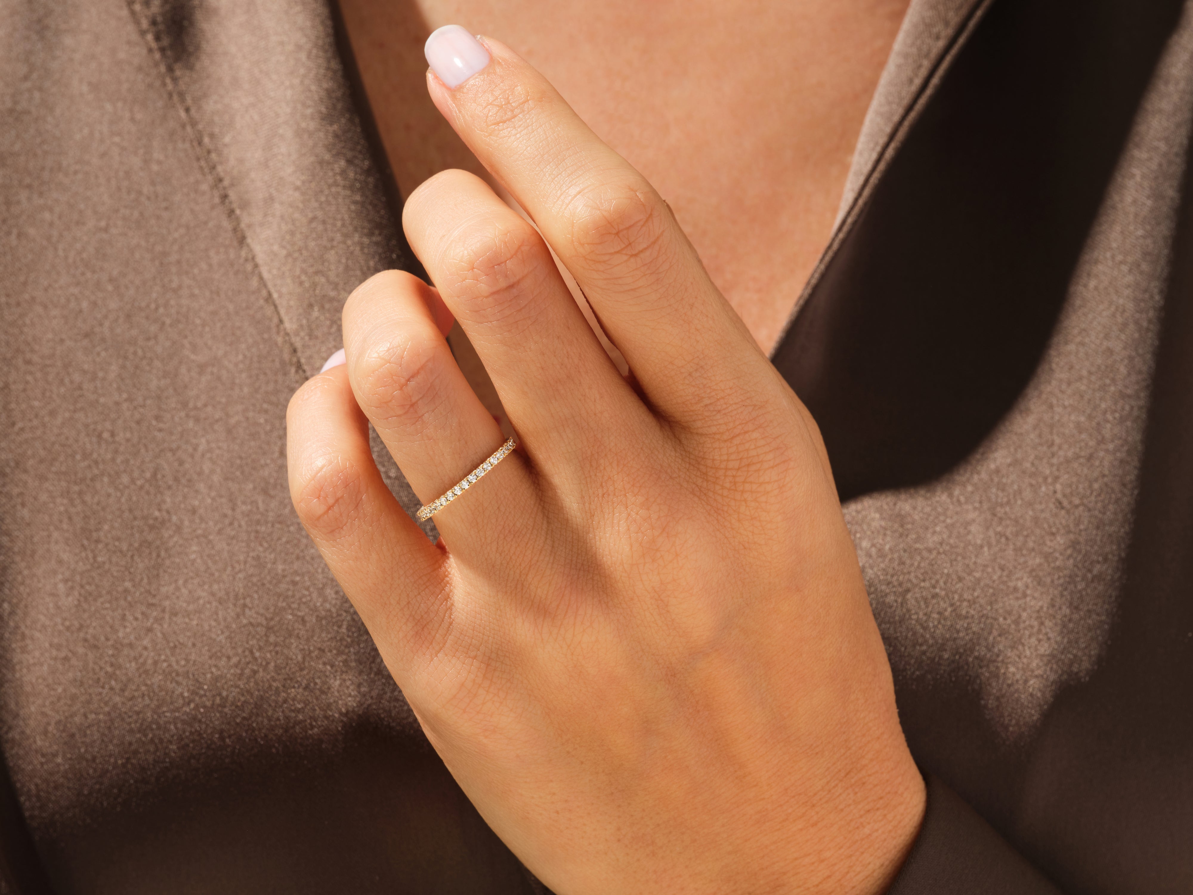Diamond eternity band on a woman's finger, fine jewelry