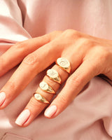Gold initial signet rings on a hand, jewelry