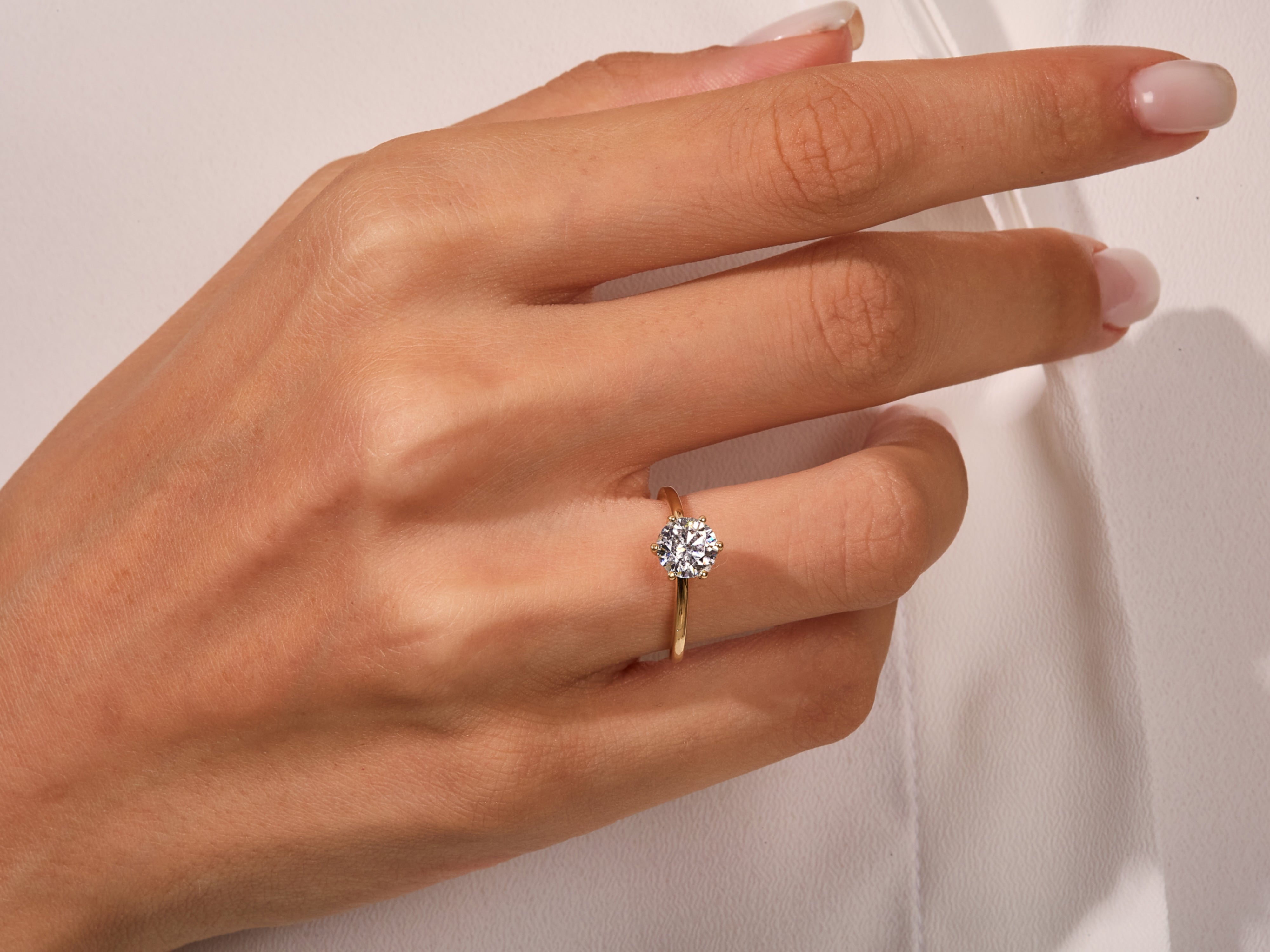 Diamond solitaire ring on a hand, fine jewelry