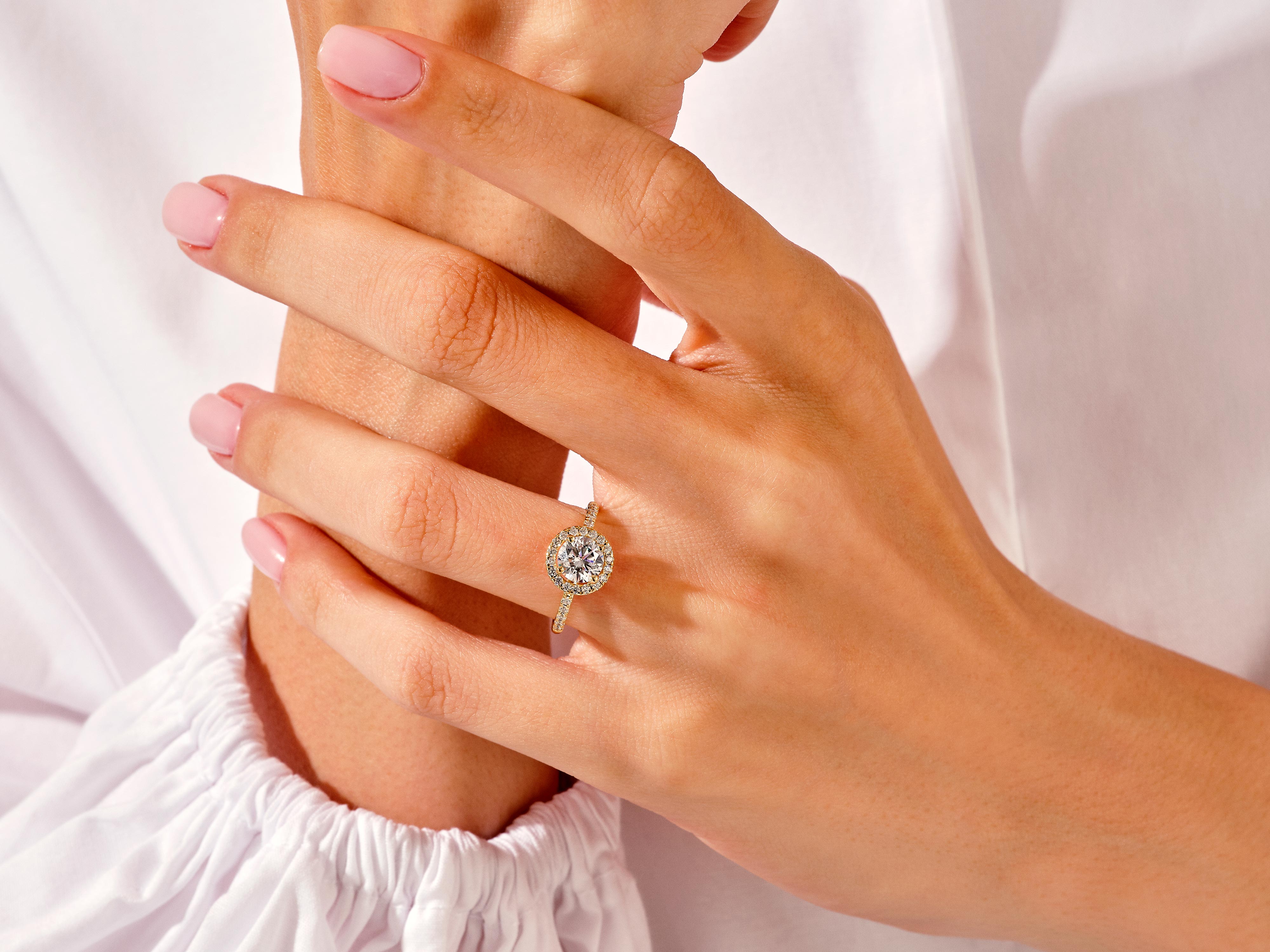 Diamond halo engagement ring on a woman's hand