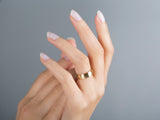 Elegant gold ring on a woman's hand, jewelry photography